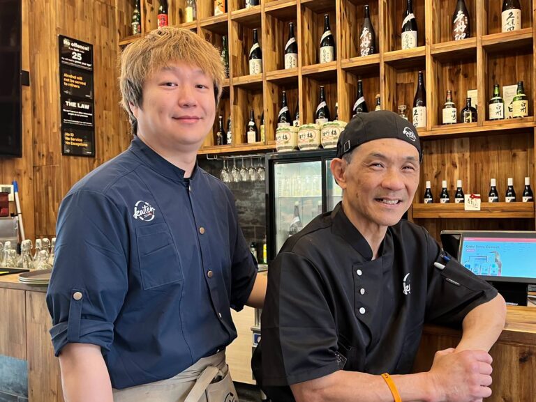 Two Kaiten team members standing behind the restaurant bar